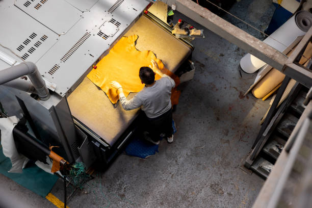 employé coupant le cuir d’une tannerie à l’aide d’une découpeuse laser - découpe laser photos et images de collection